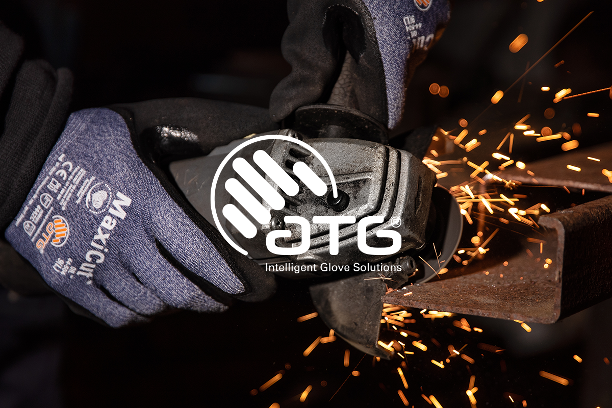 Händer med skyddshandskar som använder en vinkelslip, gnistor flyger från metallstycke. Klickbar länk till ATG-produkter